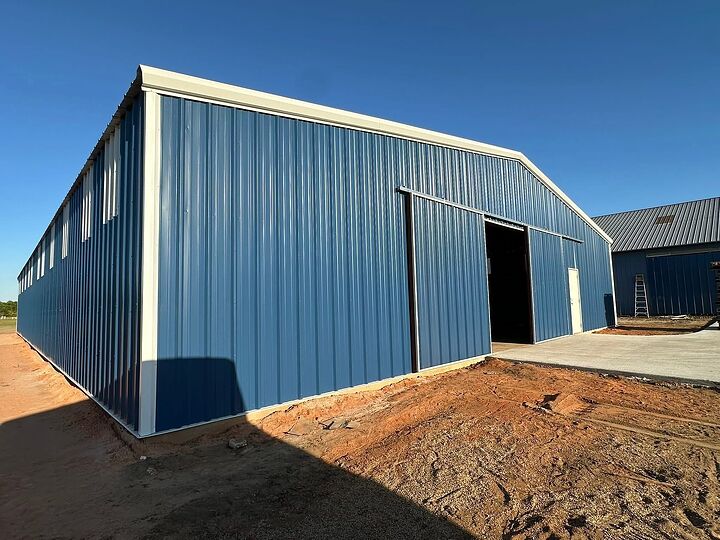 Blue metal barn with white trim, a large sliding door and clerestory windows