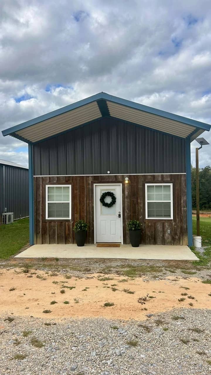Metal cabin with wood siding accent and covered front porch
