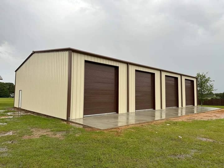 Tan storage building with four brown roll-up doors