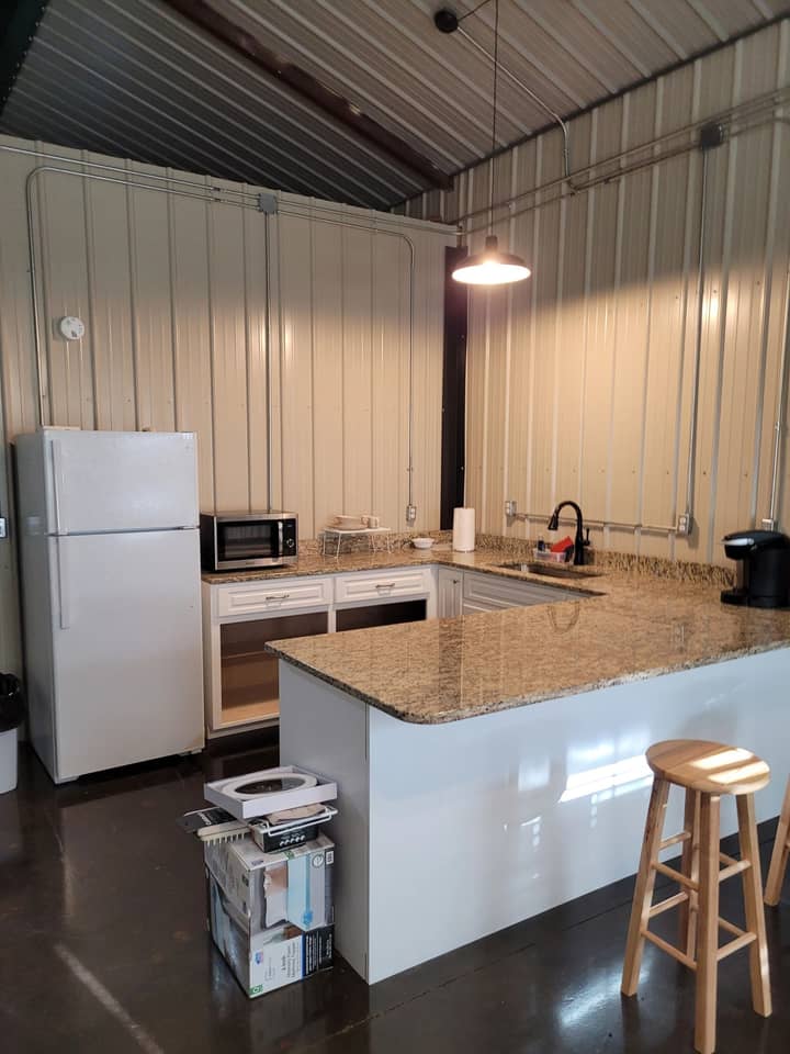 Finished kitchen inside a metal building with stone countertop island