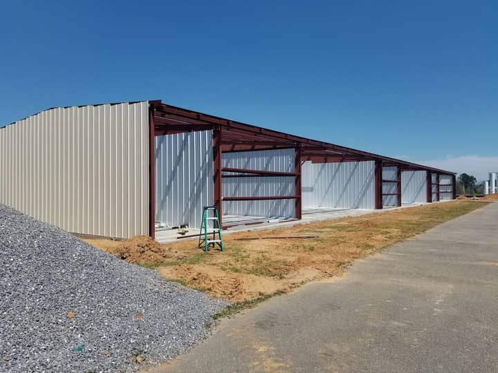 Long metal building with red steel framing going up