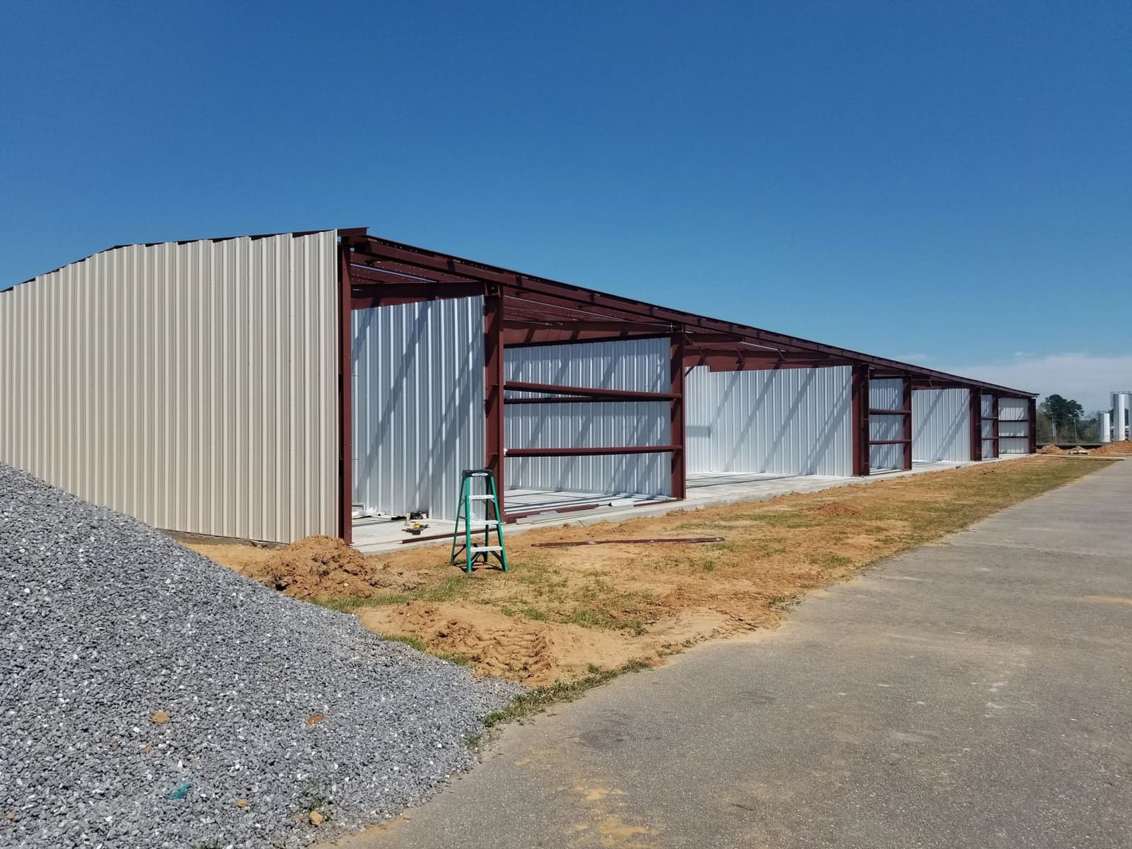 Long metal building with red steel framing going up