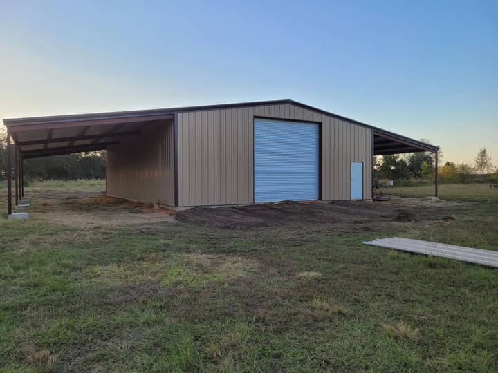 Metal shop with lean-to porch and blue roll-up door