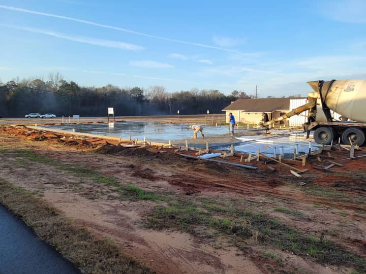Concrete truck pouring a formed slab for a commercial building