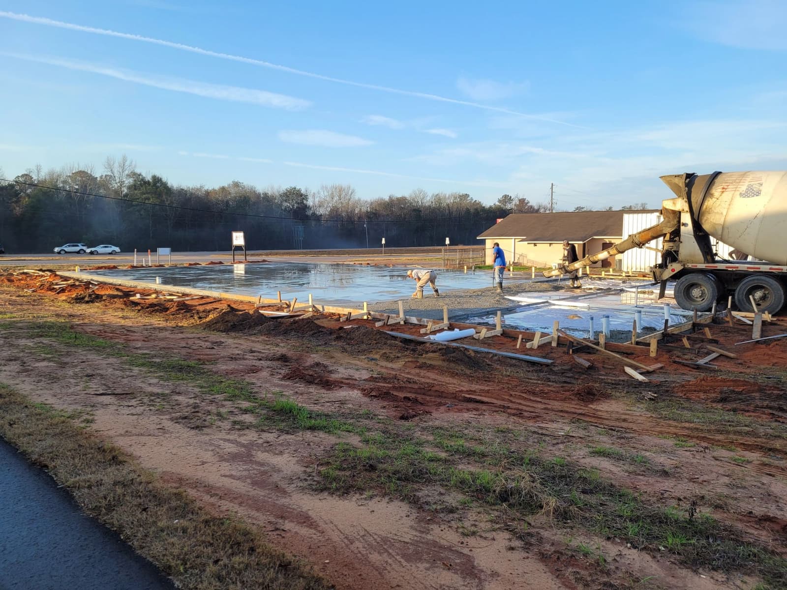 Concrete truck pouring a formed slab for a commercial building