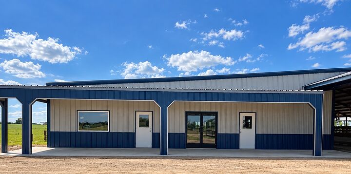 Tan metal building with blue wainscot and trim and a covered front porch