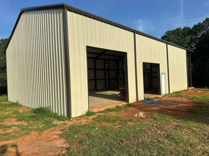 Tan two-bay metal shop building with open doors