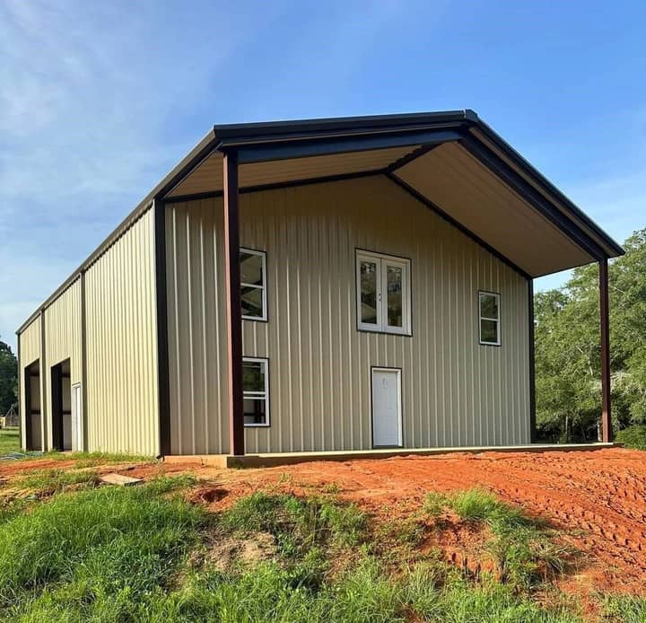 Two-story metal barndominium with wraparound porch