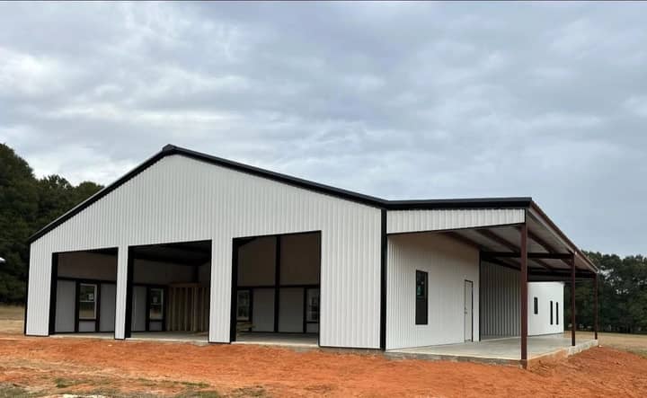 White metal barndominium with three bays and a covered porch
