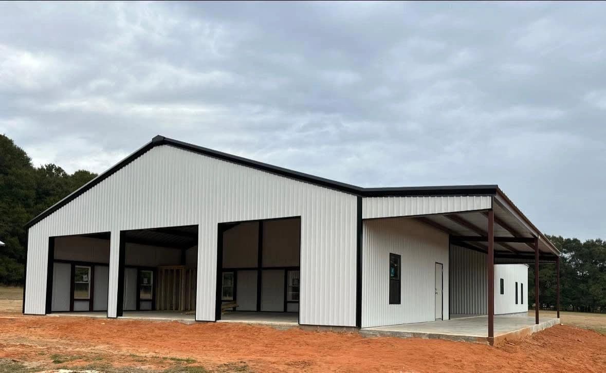 White metal barndominium with three bays and a covered porch